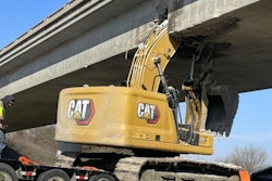 The excavator, a Caterpillar 323, was being hauled with its boom raised when it struck the bridge.