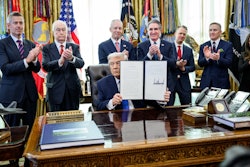 President Donald Trump holds up the executive order creating the Freedom 250 Grand Prix