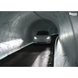 Tesla vehicle driving through illuminated underground tunnel with The Boring Company branding