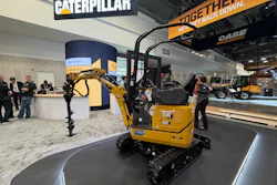 Caterpillar exhibition booth displaying yellow CAT 301 mini excavator with branded signage and visitors at trade show