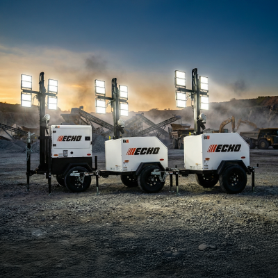 Three ECHO portable light towers with LED lighting arrays positioned on a construction site at sunset