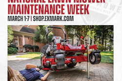 Technician performing maintenance on red Exmark zero-turn mower during National Lawn Mower Maintenance Week promotion