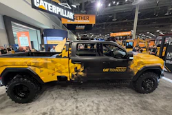 Yellow and black Caterpillar branded pickup truck on display at industrial trade show