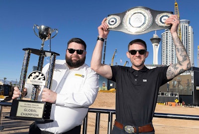 Tom March (right) holds his championship belt after being named the top global Caterpillar technician.