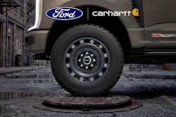 Ford truck with Carhartt collaboration branding parked on wet urban street with industrial building backdrop
