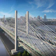 Modern cable-stayed bridge spanning a river with city skyline and blue sky