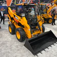 Yellow and black BULL skid steer loader with bucket attachment displayed at industrial equipment trade show