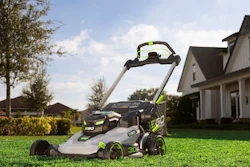 EGO Power+ electric lawn mower on manicured lawn with suburban home and landscaping in background