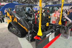 Hyundai heavy equipment display at trade show featuring yellow and black skid steer loader with red snow plow attachment