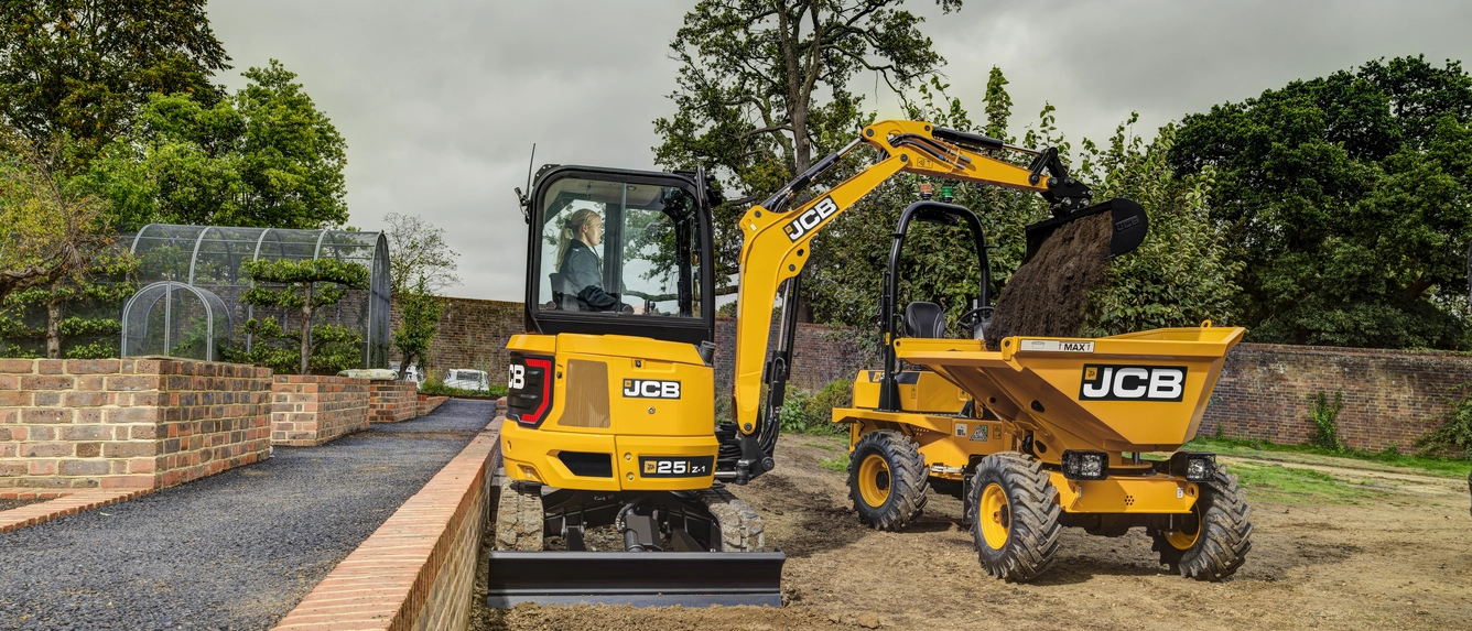 Yellow JCB mini excavator and dumper truck on a construction site with brick wall and landscaping
