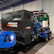 American Augers M150D mobile drilling auger on display at trade show with blue tractor unit and black equipment housing