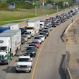 Heavy traffic congestion on multi-lane highway with trucks and vehicles during daytime.