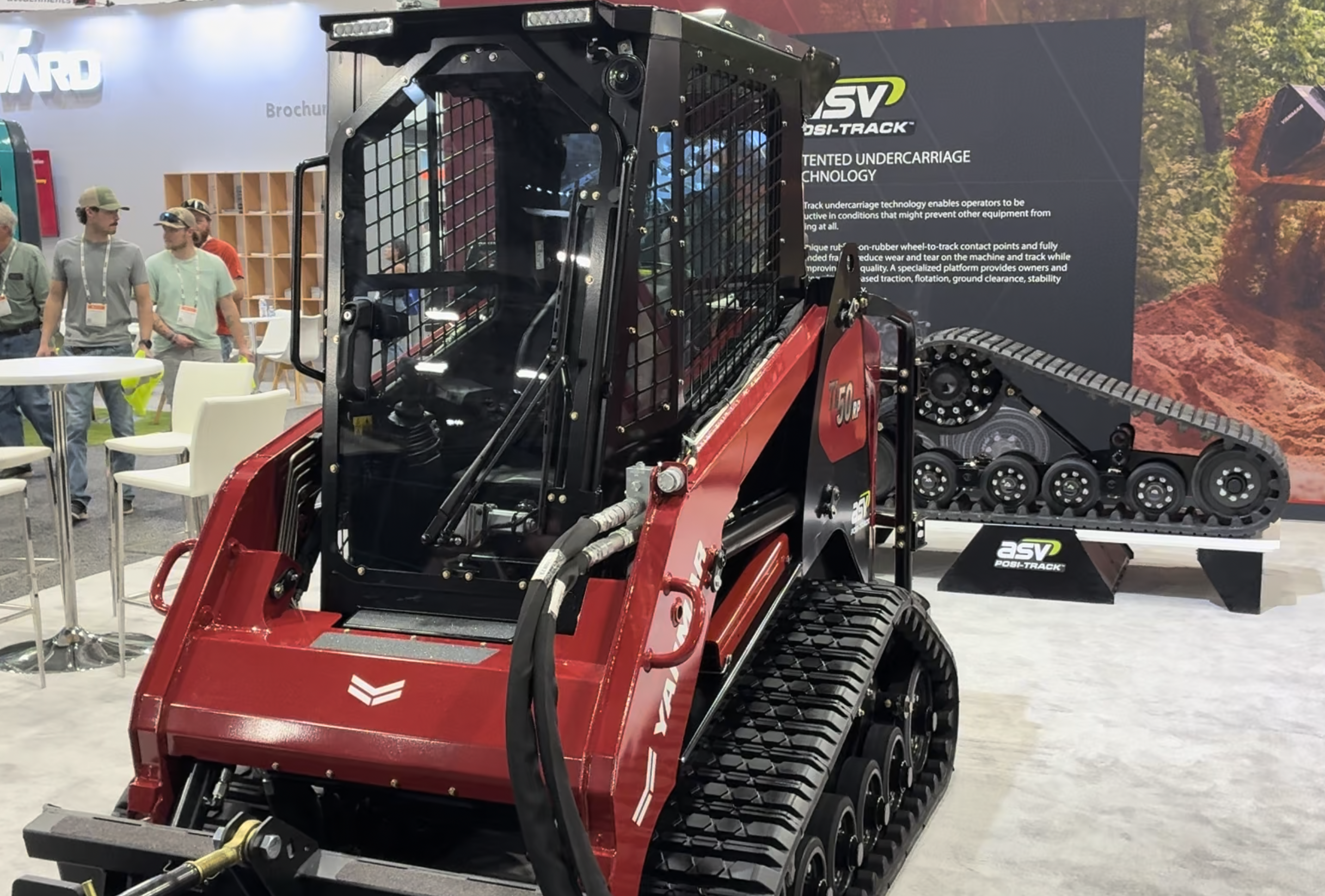 Red and black SV tracked skid steer loader with tinted undercarriage technology displayed at trade show