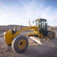 Yellow LIUGONG motor grader on construction site with blue cab and large blade