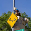 Yellow diamond-shaped warning sign with canoe icon mounted on street pole