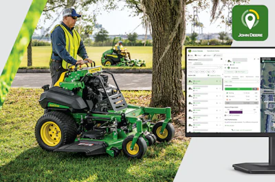 Operator on green John Deere zero-turn mower in field with fleet management software displayed on monitor