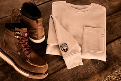 Brown leather boots and cream sweatshirt styled on wooden floor with casual fashion accessories