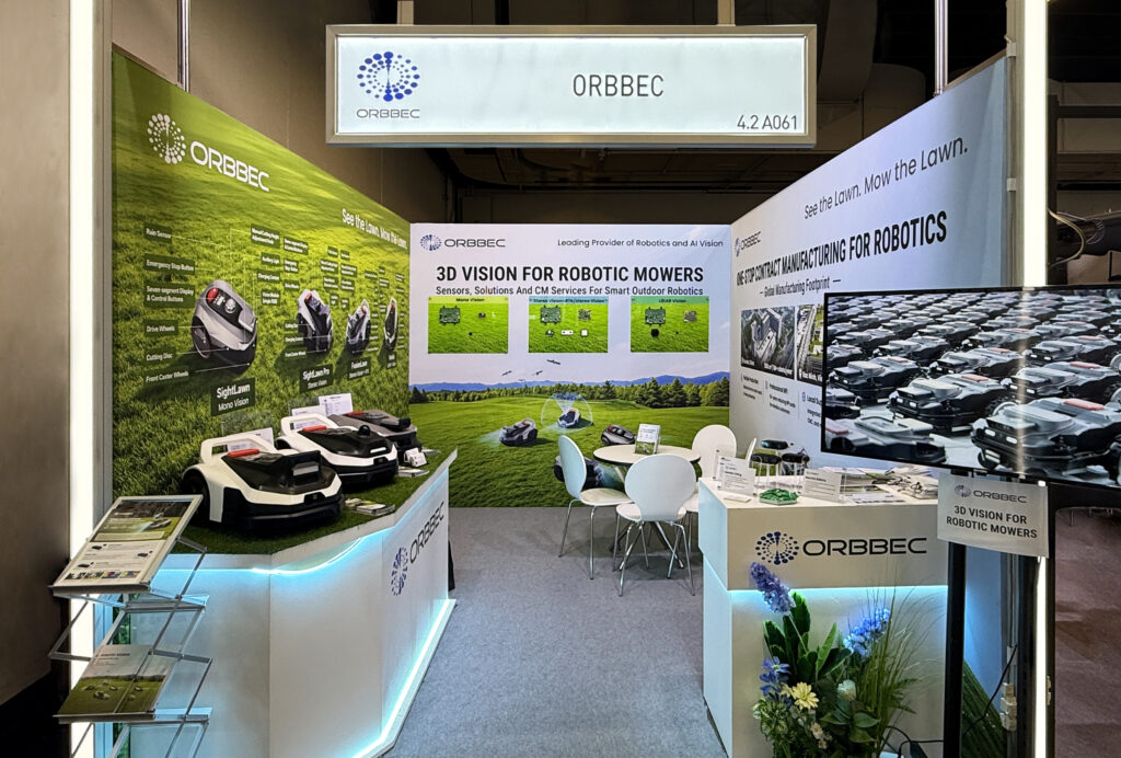 ORBBEC exhibition booth showcasing 3D vision technology for robotic mowers with product displays and interactive demo area