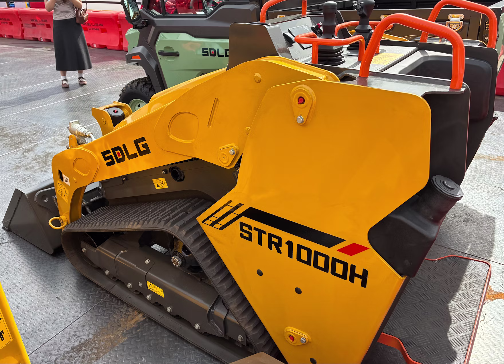 Yellow SDLG STR1000H soil compactor with tracked undercarriage displayed in equipment showroom