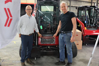 Corey Chick, plant director (left), and Cary Safe, research and development director and legacy employee (right) in front of the TL100, the 50,000th machine off the line.