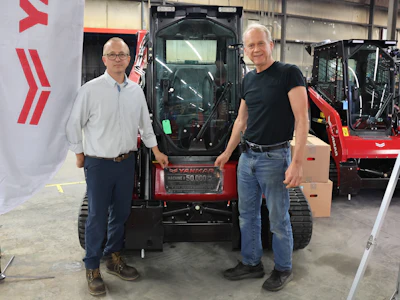 Corey Chick, plant director (left), and Cary Safe, research and development director and legacy employee (right) in front of the TL100, the 50,000th machine off the line.