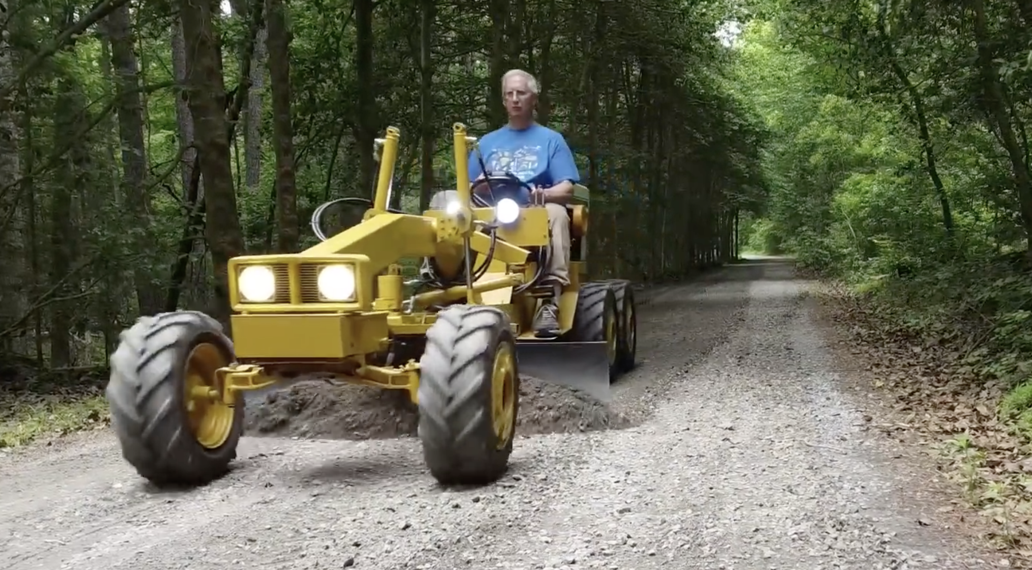Frank Smith levels the driveway with a mini motor grader he made with a 1972 Cub Cadet lawn tractor.