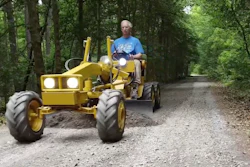 Frank Smith levels the driveway with a mini motor grader he made with a 1972 Cub Cadet lawn tractor.