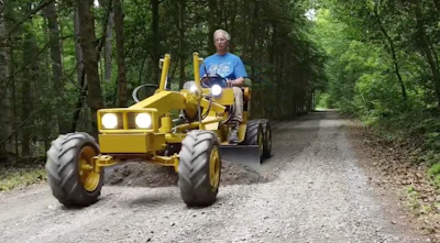 Frank Smith levels the driveway with a mini motor grader he made with a 1972 Cub Cadet lawn tractor.