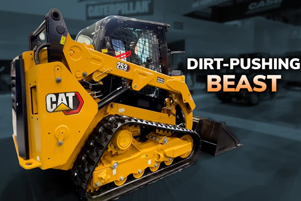 Yellow Caterpillar 289D compact track loader with marketing text 'Dirt-Pushing Beast' in industrial warehouse setting