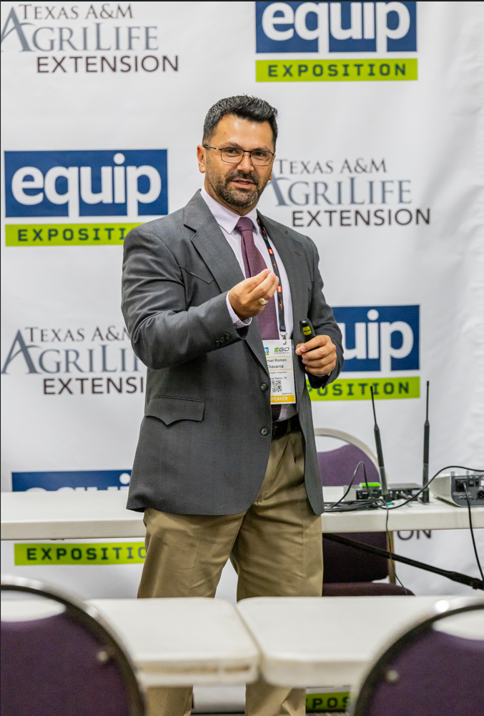 Professional man speaking at Texas A&M AgriLife Extension EQUIP Exposition conference with branded backdrop