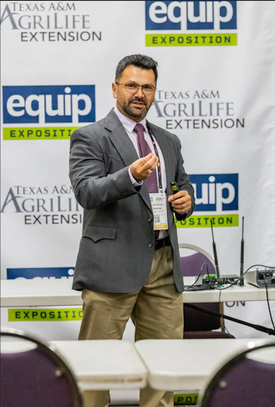Professional man speaking at Texas A&M AgriLife Extension EQUIP Exposition conference with branded backdrop