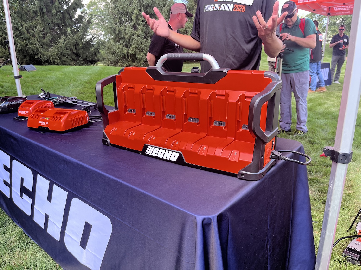 ECHO red toolbox and power tools displayed at outdoor promotional event with spectators in background