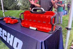 ECHO red toolbox and power tools displayed at outdoor promotional event with spectators in background