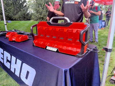 ECHO red toolbox and power tools displayed at outdoor promotional event with spectators in background