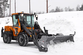 Orange wheel loader with Hilltip snow plow attachment clearing snow from a winter road