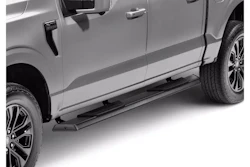 Silver pickup truck with black running boards and alloy wheels, side view