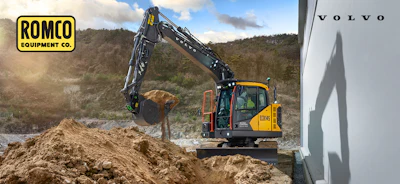 Volvo excavator with extended arm loading logs at a construction site, branded with ROMCO Equipment Co. logo