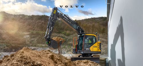 Volvo excavator operating on a construction site with earthen hillside backdrop