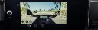 2027 GMC Sierra HD Dashboard camera view showing road ahead with trees and clear sky from vehicle interior