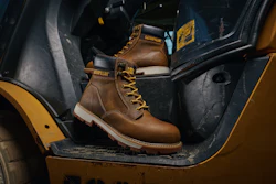 Brown leather Caterpillar work boot with yellow laces displayed in yellow vehicle interior