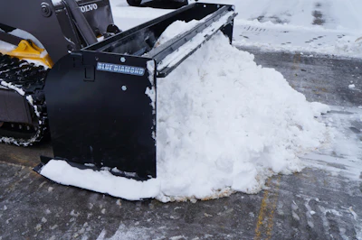 Blue Diamond snow plow attachment actively pushing accumulated snow on a paved road