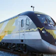 Brightline passenger train with yellow and white livery at sunset