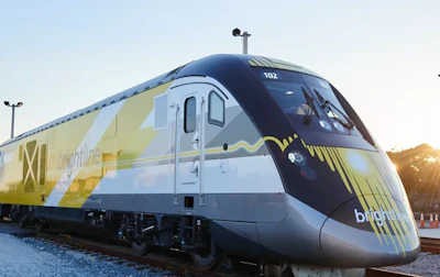 Brightline passenger train with yellow and white livery at sunset