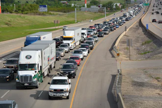 Heavy traffic congestion on multi-lane highway with semi-trucks and passenger vehicles during peak hours