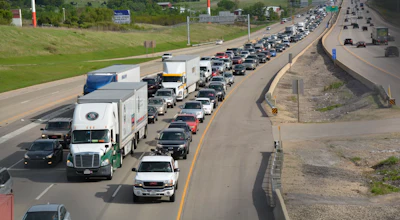 Heavy traffic congestion on multi-lane highway with semi-trucks and passenger vehicles during peak hours