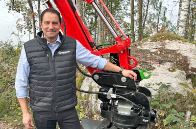 Man in Weidemann vest posing with red X07 wheel loader in forest setting