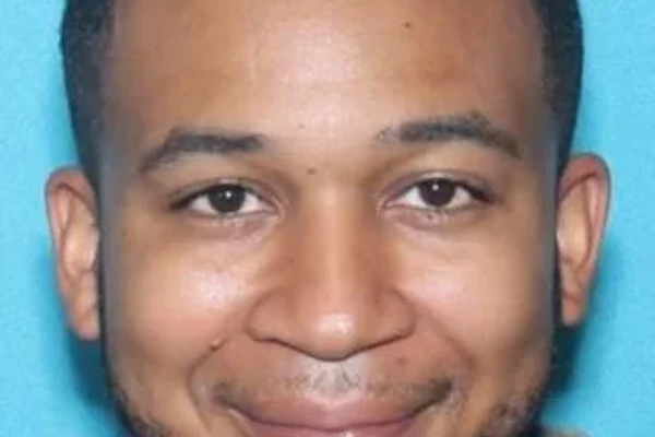 mugshot of Marvin Grant a man with short dark hair and facial hair wearing a dark shirt against a blue background