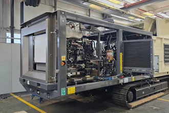 Mobile diesel generator unit with engine exposed, mounted on tracked platform in industrial warehouse facility