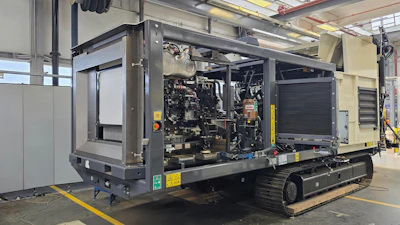 Mobile diesel generator unit with engine exposed, mounted on tracked platform in industrial warehouse facility