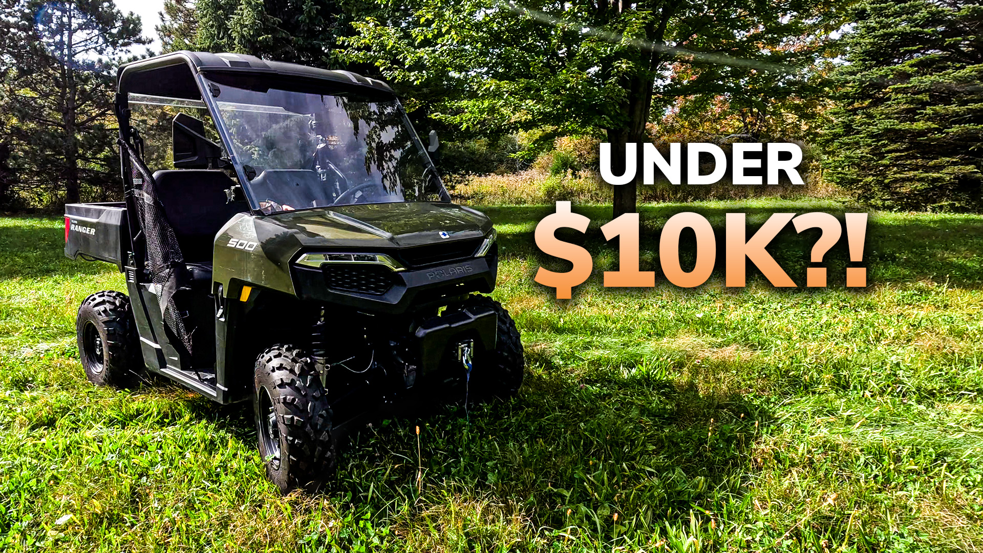 Olive green Polaris Ranger UTV parked on grass with pricing text 'Under $10K?!' overlaid, surrounded by trees